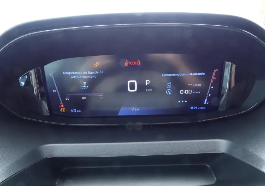 Affichage numérique du combiné de bord du Peugeot Partner 2025, avec indicateurs de vitesse, température et consommation.