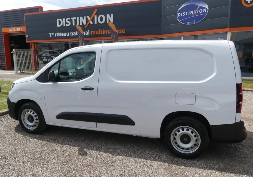 Peugeot Partner XL blanc vu de profil côté gauche, fourgon utilitaire avec protections noires sur les portières.