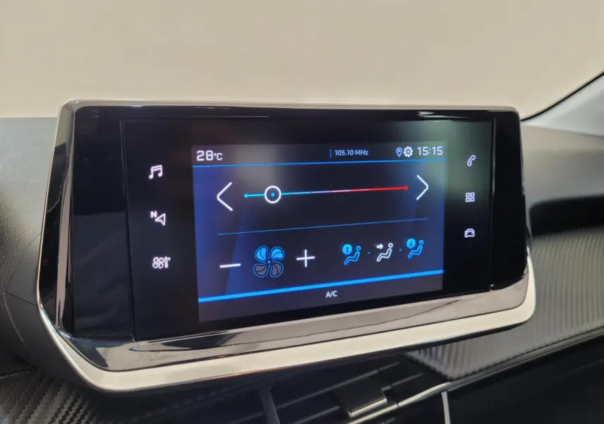 Écran tactile central affichant la climatisation dans l'habitacle d'une Peugeot 208 gris foncé, vue de face.