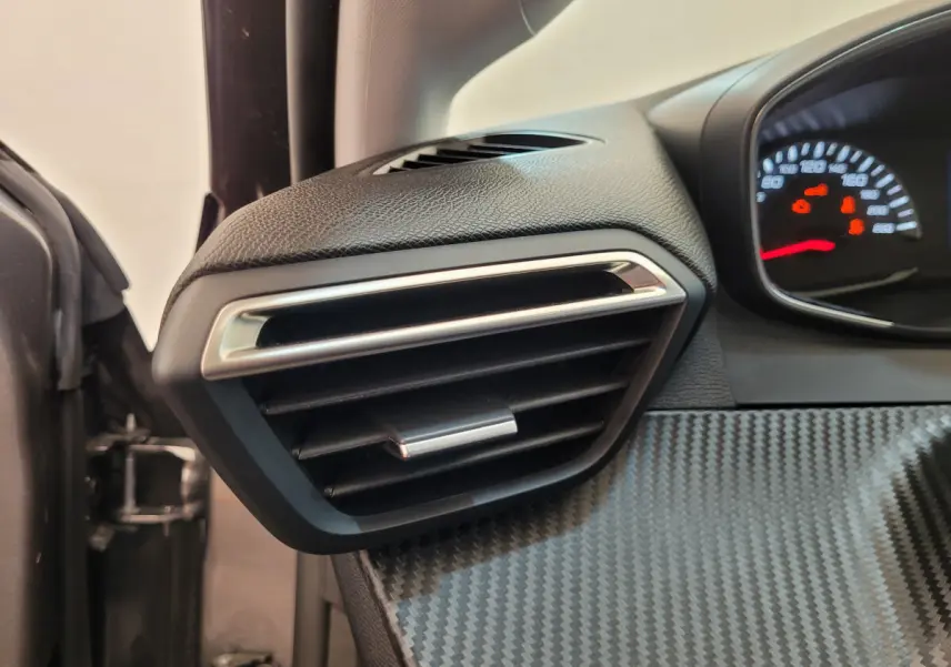 Gros plan sur la sortie d’air côté gauche du tableau de bord gris foncé de la Peugeot 208 2023 Active Pack.