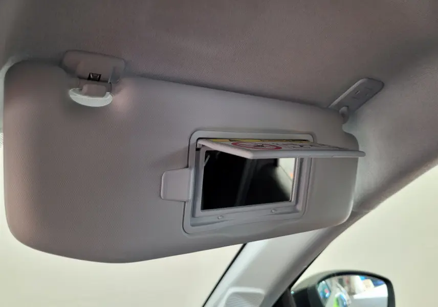 Miroir de courtoisie ouvert sur le pare-soleil côté conducteur à l'intérieur d'une Peugeot 208 gris foncé 2023