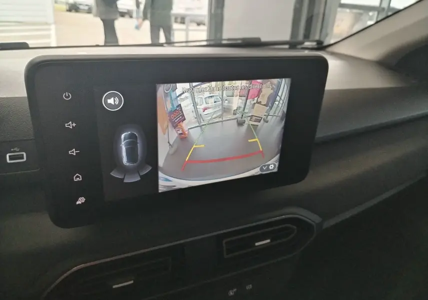 Écran central du tableau de bord du Dacia Jogger blanc 2025 montrant la caméra de recul avec guidage coloré.