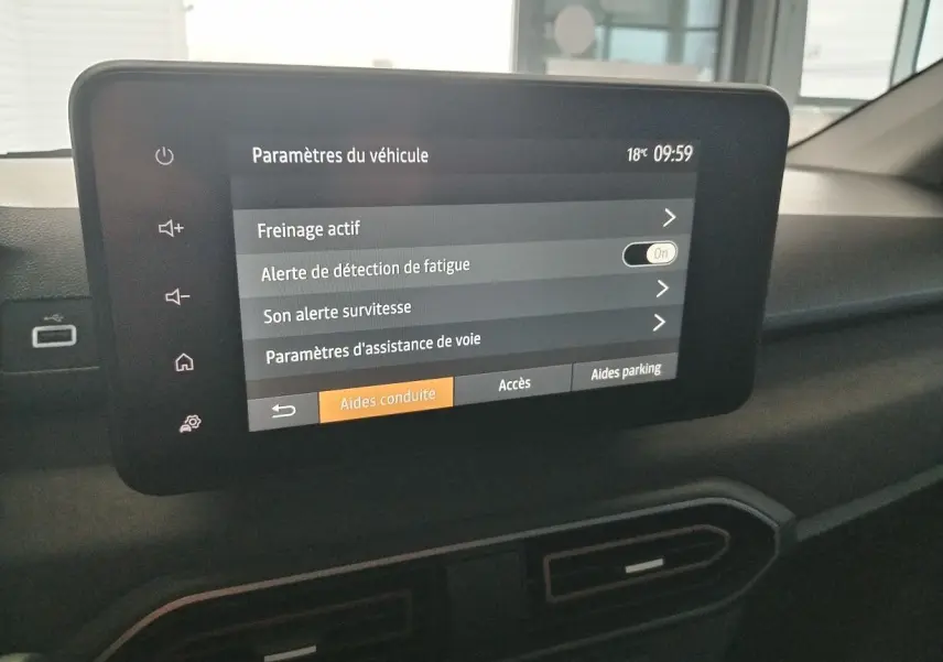 Écran tactile central du tableau de bord du Dacia Jogger blanc, affichant les paramètres d’aides à la conduite.
