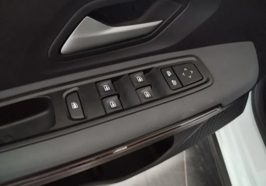 Commande des vitres et réglages des rétroviseurs sur la portière côté conducteur d'un Dacia Jogger blanc 2025.
