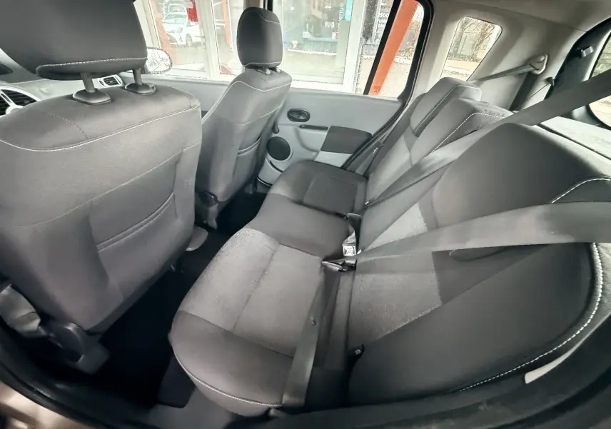 Vue intérieure arrière montrant les sièges en tissu gris noir et les ceintures de sécurité de la Renault Modus 2011.