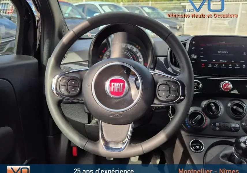 Vue intérieure centrée sur le volant noir du Fiat 500C 2024 avec tableau de bord et écran tactile visibles.