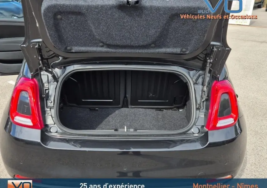 Vue arrière d'une FIAT 500C noire 2024 avec coffre ouvert, montrant l'espace de rangement et les feux arrière rouges.