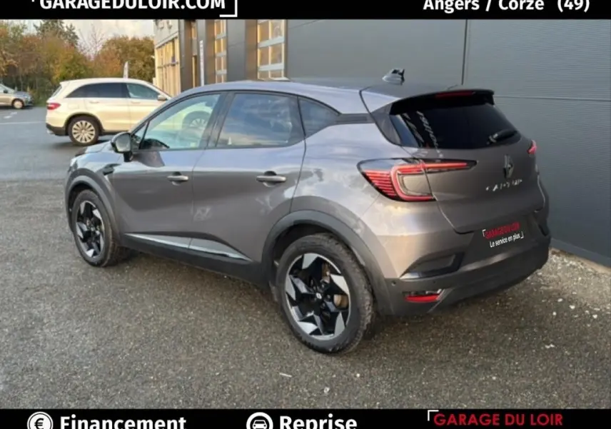 Vue 3/4 arrière droite d'un Renault Captur Techno TCe 90 gris foncé avec jantes noires et vitres teintées.