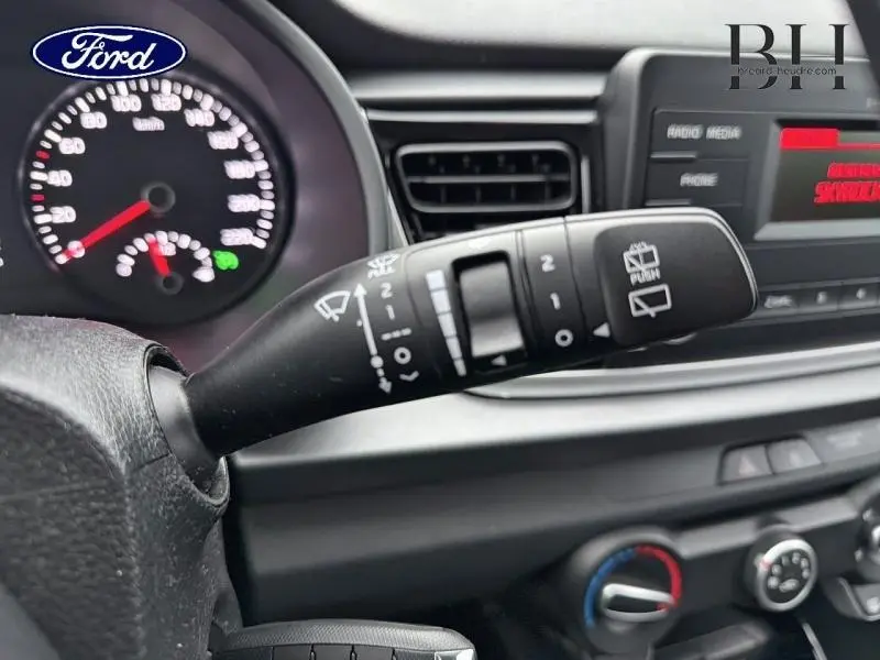 Gros plan sur la commande d’essuie-glace d’un tableau de bord noir d’une KIA RIO 2018, détails des commandes visibles.