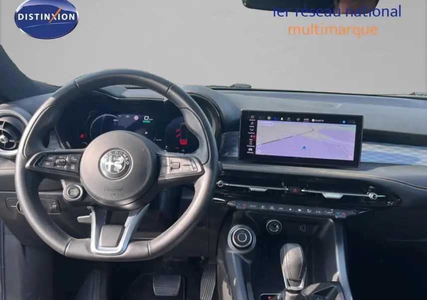 Vue intérieure du poste de conduite de l'Alfa Romeo Tonale gris Vesuvio, avec volant, tableau de bord digital et écran central tactile.