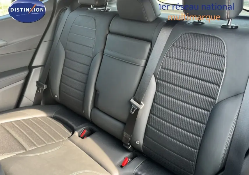 Vue intérieure des sièges arrière en cuir noir de l'Alfa Romeo Tonale 1.5 Hybrid 2023, avec ceinture de sécurité visible.