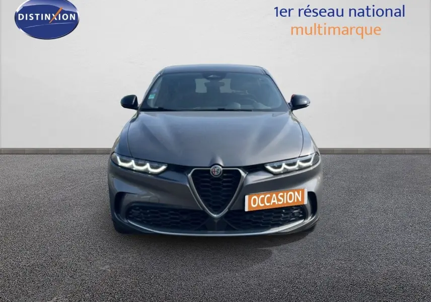 Vue de face de l'Alfa Romeo Tonale gris Vesuvio métal avec calandre caractéristique et phares LED allumés.