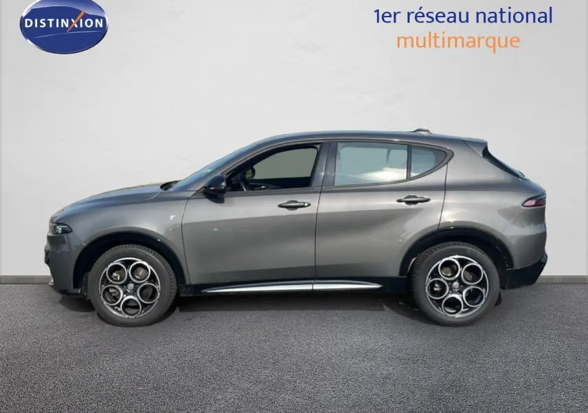 Vue de profil côté gauche d'un Alfa Romeo Tonale gris Vesuvio métallisé avec jantes distinctives à cinq cercles.