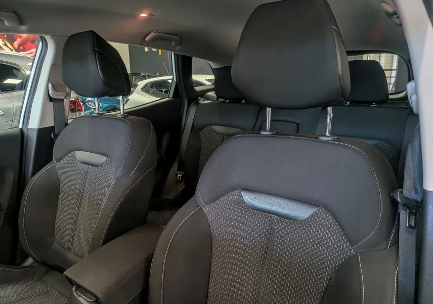 Vue intérieure des sièges avant en tissu noir du Renault Kadjar 2021, avec appuie-têtes et ceintures visibles.