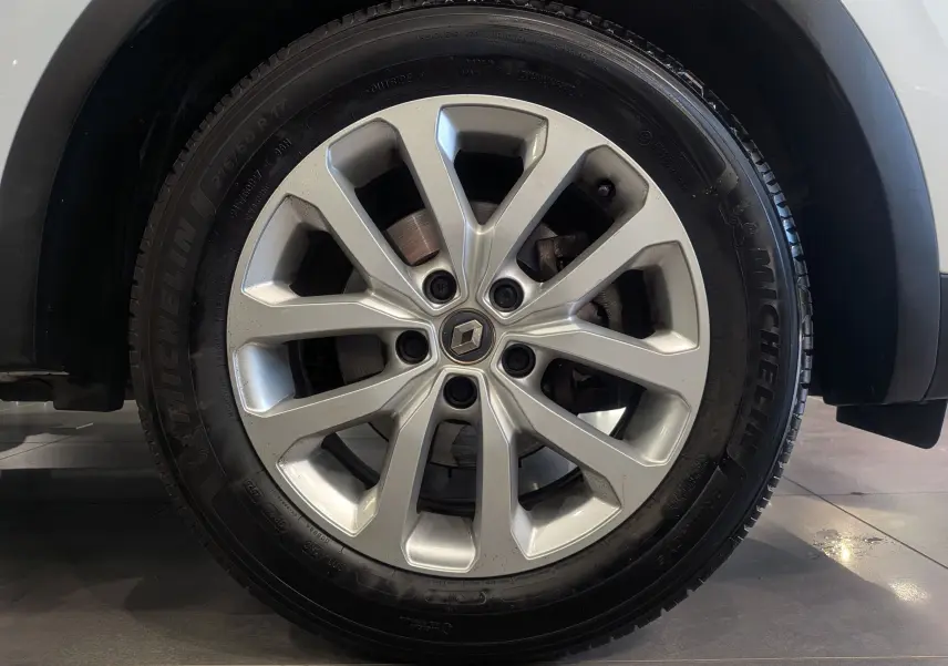 Gros plan sur la roue avant droite d’un Renault Kadjar blanc Glacier, jante alliage 17 pouces avec logo Renault central.