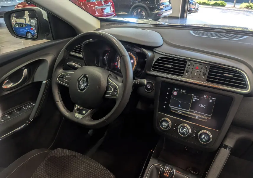 Vue intérieure côté conducteur du Renault Kadjar 2021, tableau de bord noir avec écran tactile et volant multifonction.