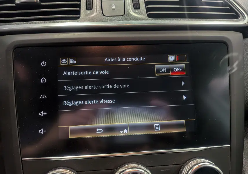 Écran tactile central du Renault Kadjar blanc glacier 2021 affichant les aides à la conduite, vue rapprochée de l'intérieur.