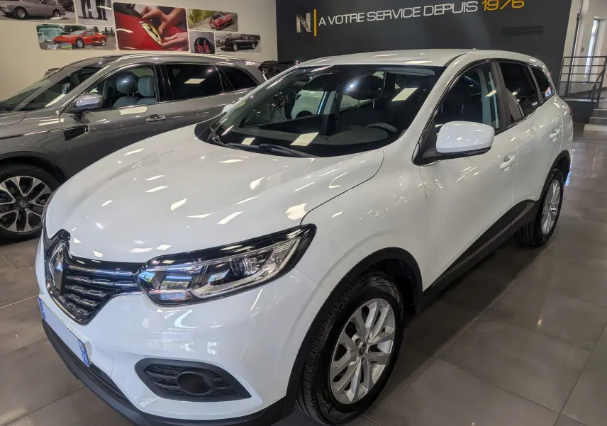 Renault Kadjar Blanc Glacier en 3/4 avant droit, SUV compact avec jantes alliage et phares LED distinctifs.