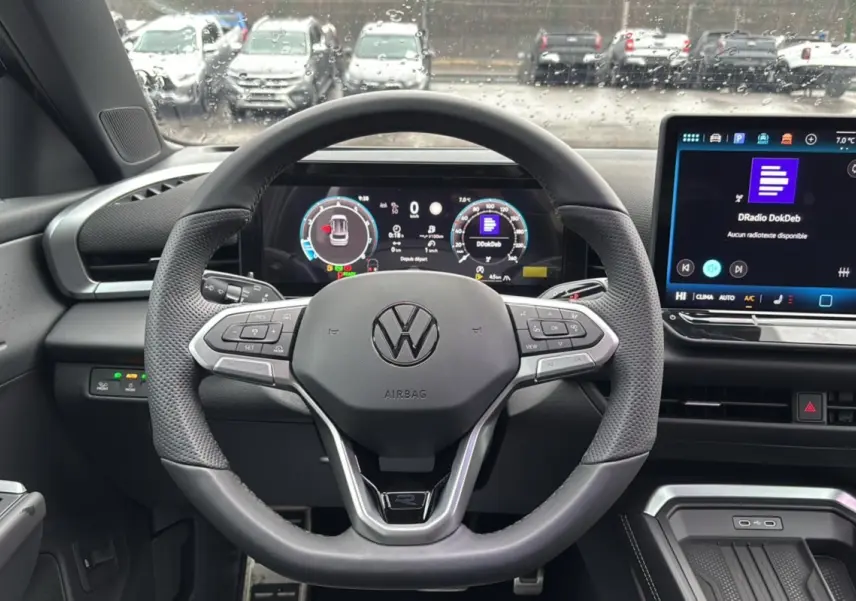Vue intérieure centrée sur le volant cuir multifonctions du Volkswagen T-Roc 2026 avec écran digital et tableau de bord numérique.