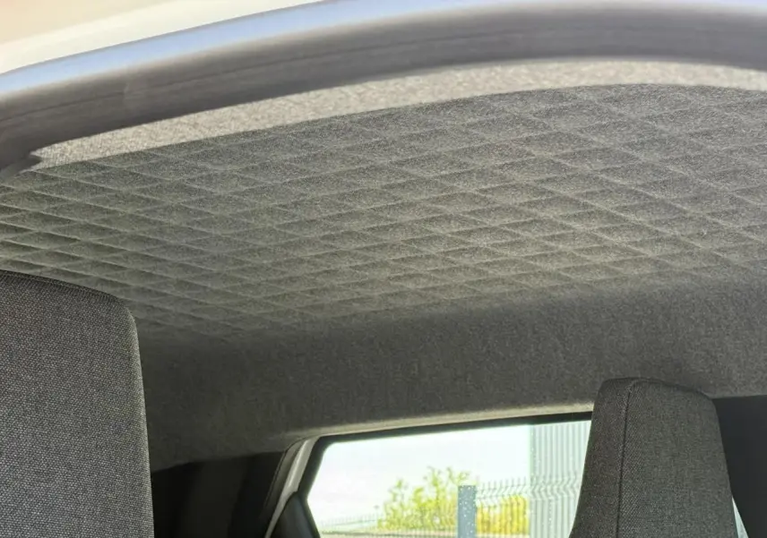 Intérieur de la Renault R5 E-Tech 2026, vue sur le ciel de toit gris matelassé et partie supérieure des sièges arrière.