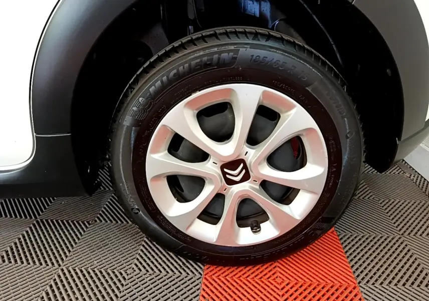 Gros plan sur la roue avant gauche blanche d'une Citroën C3 avec jante en alliage et pneu Michelin.