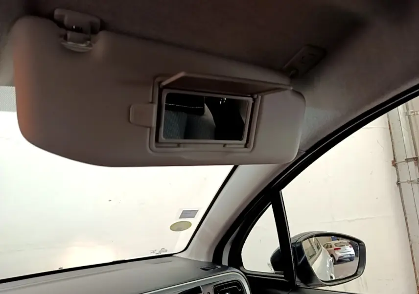 Intérieur côté conducteur de la Citroën C3 blanche 2021, avec pare-soleil rabattable et miroir de courtoisie ouvert.