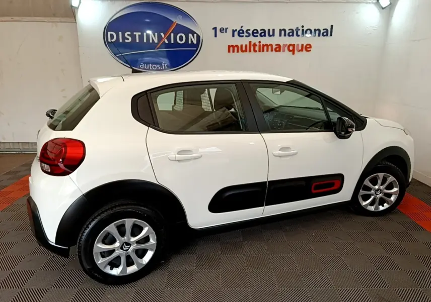 Vue latérale droite d'une Citroën C3 blanche 2021 avec protections noires et insert rouge sur la porte arrière.