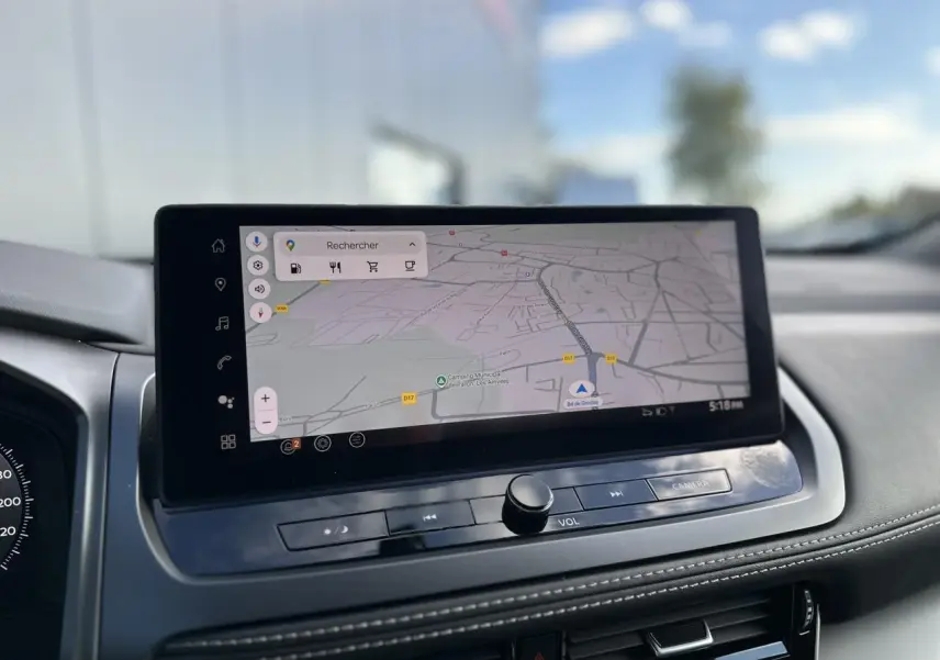 Vue intérieure du tableau de bord du Nissan Qashqai 2025, écran tactile affichant une carte de navigation.