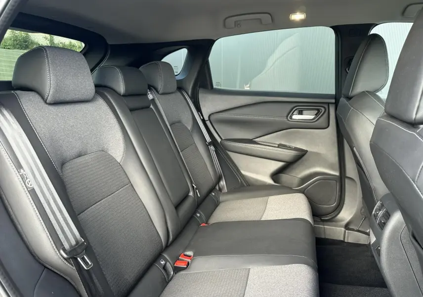 Vue intérieure côté droit des sièges arrière en sellerie mixte noir et tissu gris du Nissan Qashqai 2025.