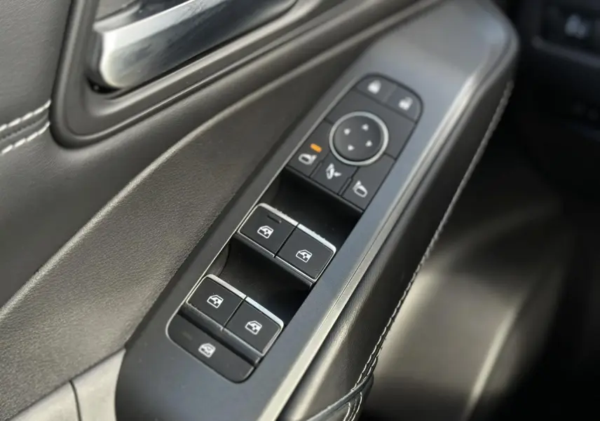 Gros plan sur les commandes des vitres électriques et rétroviseurs sur la porte côté conducteur du Nissan Qashqai 2025.