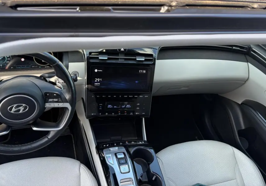 Intérieur clair du Hyundai Tucson 2022, vue de dessus sur le tableau de bord, volant cuir et console centrale tactile.