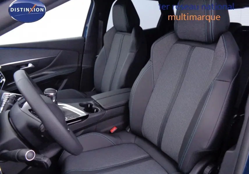 Vue intérieure côté conducteur du Peugeot 3008 2023, sièges tissu et cuir noir avec surpiqûres bleues.