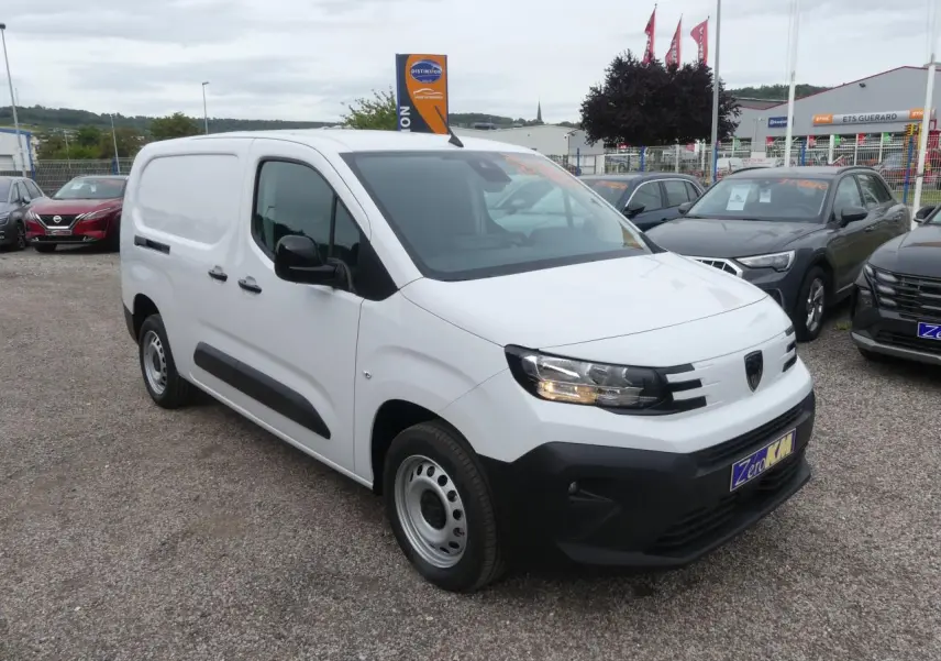 Peugeot Partner blanc vue 3/4 avant droit avec boucliers noirs et jantes tôle grises sur parking.