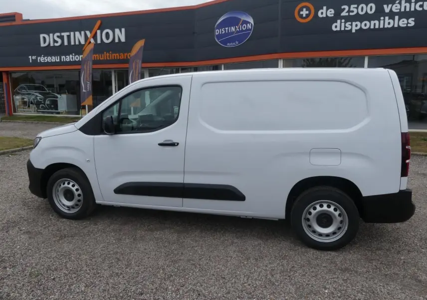 Vue de profil côté gauche d'un utilitaire Peugeot Partner blanc avec porte latérale coulissante et jantes tôles grises.