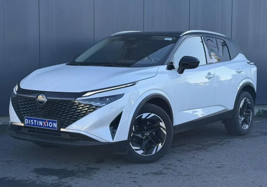 Nissan Qashqai 2025 blanc nacré avec toit noir, vue 3/4 avant droit, jantes alliage noires et calandre distinctive.