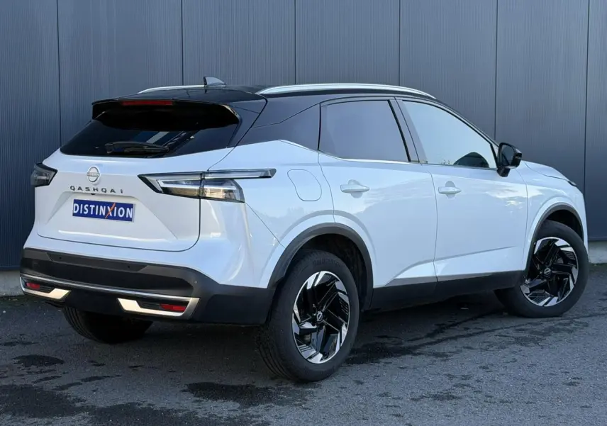 Vue 3/4 arrière droite du Nissan Qashqai blanc nacré avec toit noir et jantes alliage noires.