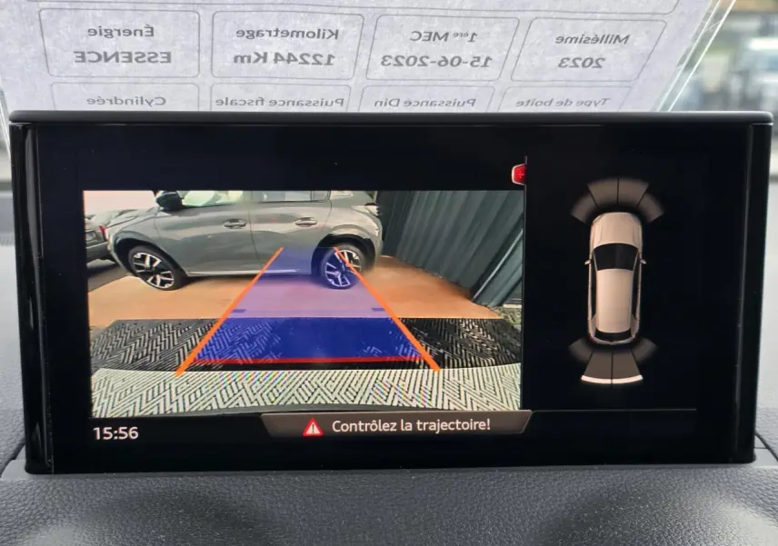 Vue écran caméra de recul montrant un Audi Q2 noir mythic garé côté droit avec lignes de guidage orange.