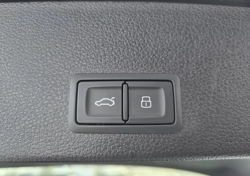 Boutons de déverrouillage du coffre et de verrouillage centralisé sur garniture intérieure noire d'Audi Q2 noir Mythic 2023.