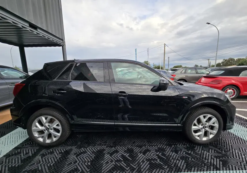 Audi Q2 noir mythic vue de profil côté gauche, avec jantes aluminium 5 branches doubles et vitres arrière surteintées.