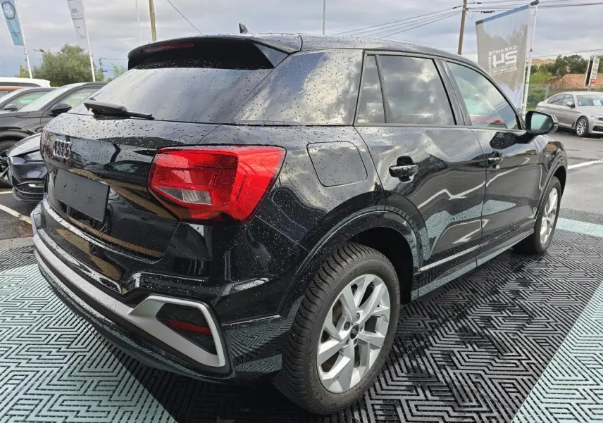 Audi Q2 noir mythic vue 3/4 arrière droit avec jantes aluminium 5 branches doubles et vitres surteintées.