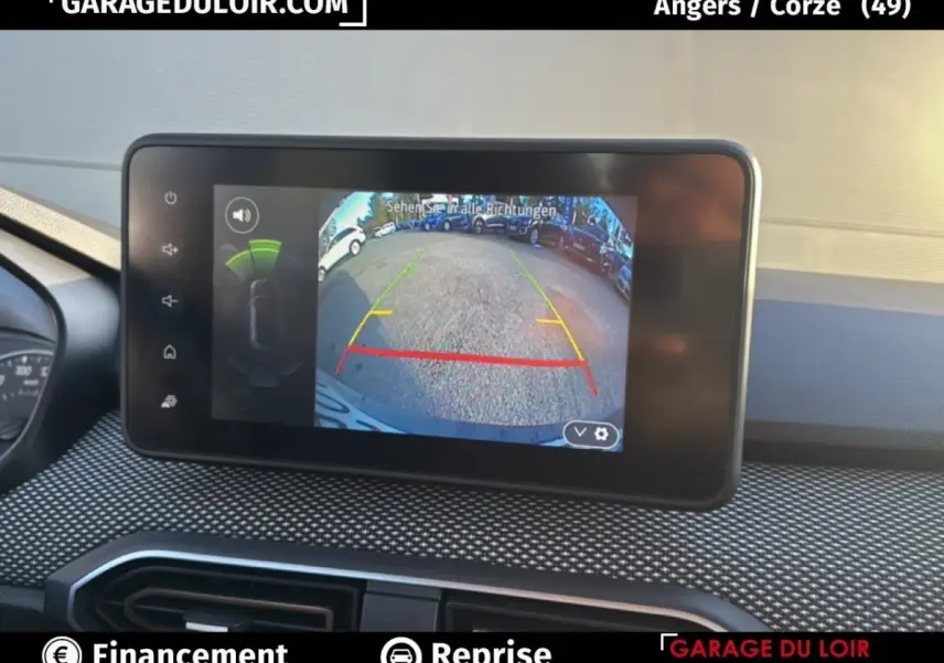 Écran central de la Dacia Sandero Expression TCe 90 2025 montrant la caméra de recul avec lignes de guidage colorées.