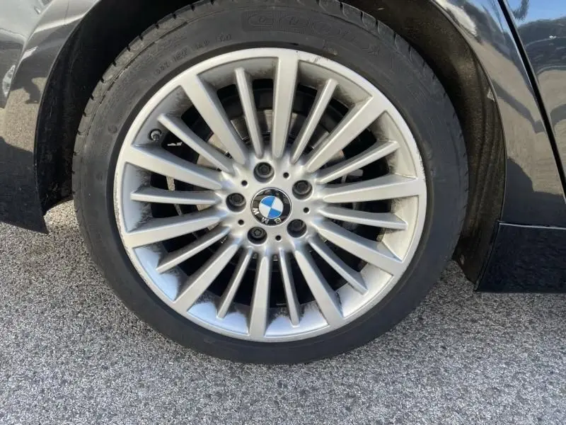Gros plan sur la jante avant droite en alliage argentée d’une BMW Série 4 Gran Coupé noir métal de 2018.