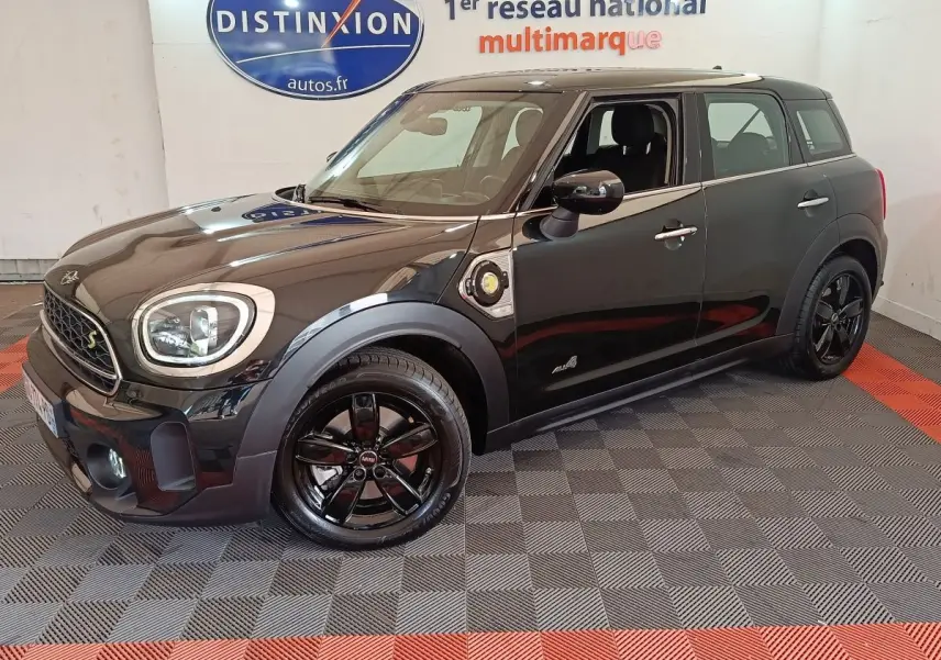 Vue 3/4 avant droite d'un MINI Countryman Cooper SE noir avec jantes noires et détails hybrides visibles sur l'aile.
