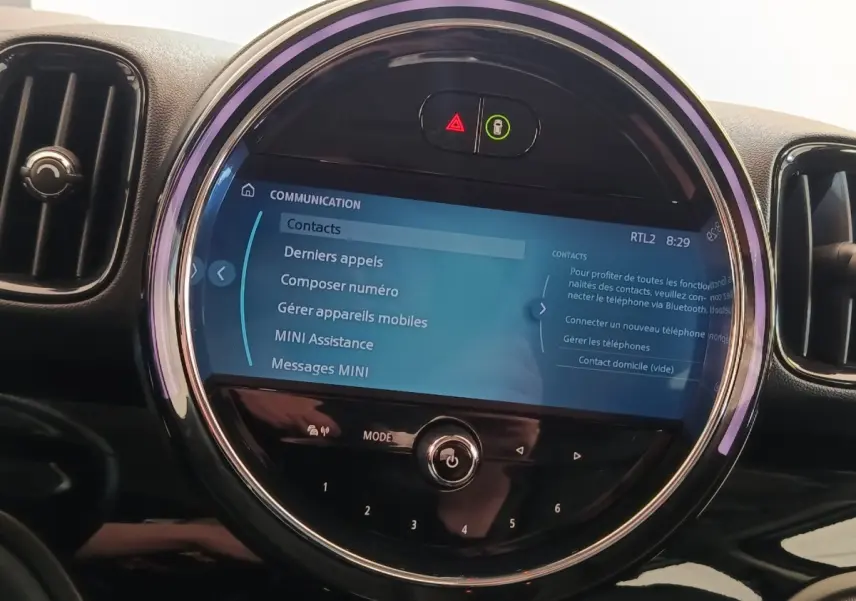 Gros plan sur l’écran tactile central rond du tableau de bord du MINI Countryman noir, affichant le menu communication.