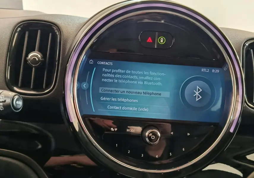 Gros plan sur l’écran tactile central rond du tableau de bord du MINI Countryman noir, affichant la connexion Bluetooth.