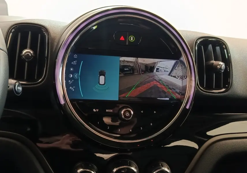 Vue rapprochée du tableau de bord noir du MINI Countryman 2023 avec écran central circulaire affichant la caméra de recul.