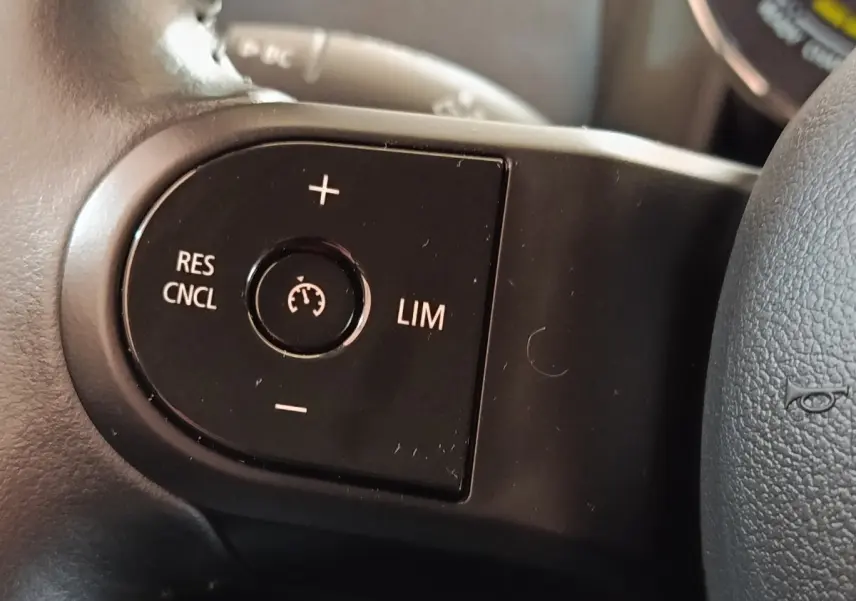 Gros plan sur les commandes du régulateur de vitesse au volant cuir noir du MINI Countryman Cooper SE 2023.