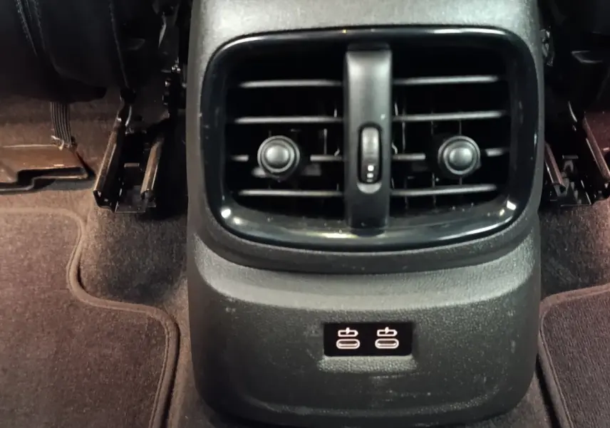 Gros plan sur la console arrière noire du MINI Countryman 2023 avec bouches d’aération et ports USB visibles.