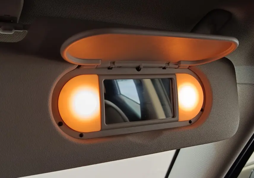 Miroir de courtoisie éclairé sur pare-soleil intérieur du MINI Countryman Cooper SE noir, vue rapprochée côté conducteur.