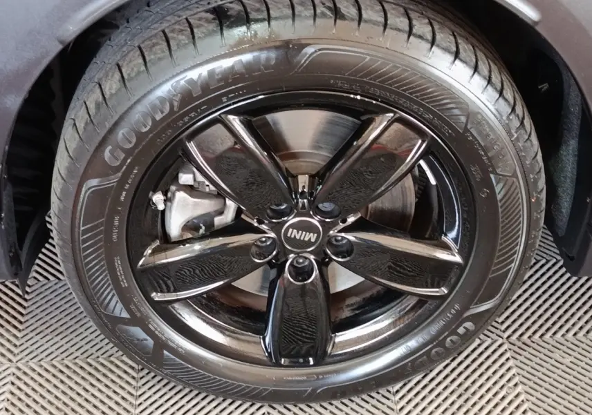 Gros plan sur la roue avant droite noire brillante d’un MINI Countryman Cooper SE 2023 avec pneu Goodyear.